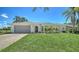 Inviting single-story home with a well-maintained lawn and landscaped facade and a two-car garage at 4409 Eleuthera Ct, Sarasota, FL 34233