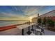 Outdoor space with table set for wine and a view of the ocean at sunset at 4557 Bay Club Dr, Bradenton, FL 34210