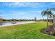 Landscaped backyard with lake view, lush grass, and palm trees at 4727 Motta Ct, Bradenton, FL 34211