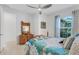 Bedroom with wooden dresser and bed featuring blue and gray bedding, and a window at 4727 Motta Ct, Bradenton, FL 34211