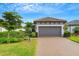 House exterior featuring a gray garage door, landscaping, and a brick driveway at 4727 Motta Ct, Bradenton, FL 34211