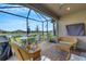 Screened patio with wicker furniture, offering a view of the lake at 4727 Motta Ct, Bradenton, FL 34211