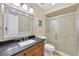 Bathroom with dark granite countertop, wood cabinets, and a shower at 504 Spring Lakes Blvd # 504, Bradenton, FL 34210