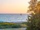 Tranquil beach view with sailboat at sunset at 507 Casey Key Rd, Nokomis, FL 34275