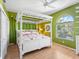Green bedroom with white canopy bed and wood floors at 508 Siesta Dr, Sarasota, FL 34242