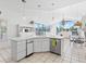 Open kitchen boasting white cabinets, stainless steel appliances & large island at 508 Siesta Dr, Sarasota, FL 34242