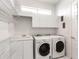 Laundry room with washer, dryer, and ample shelving at 508 Siesta Dr, Sarasota, FL 34242
