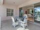 Patio with glass-top table and wicker chairs near sliding doors at 508 Siesta Dr, Sarasota, FL 34242
