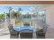 Covered patio with glass table and wicker chairs overlooking canal at 508 Siesta Dr, Sarasota, FL 34242