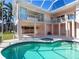 Inviting pool area with attached spa, covered patio, and second story balcony with white railings at 508 Siesta Dr, Sarasota, FL 34242