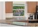Kitchen sink with granite countertops and a view of the neighborhood through the window at 607 Marcus St # 27, Venice, FL 34285