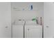 In-unit laundry room with a stacked washer and dryer and overhead shelf at 607 Marcus St # 27, Venice, FL 34285
