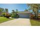 Gray house with attached garage and lush landscaping at 8186 Shadow Pine Way, Sarasota, FL 34238