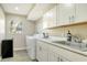 Laundry room with washer, dryer, sink, and cabinets at 8186 Shadow Pine Way, Sarasota, FL 34238