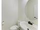 Small bathroom with toilet, sink, and rounded mirror at 865 Molly Cir, Sarasota, FL 34232