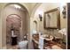 Half bathroom featuring an onyx vessel sink, decorative mirror, and brick accent wall at 8855 Midnight Pass Rd, Sarasota, FL 34242