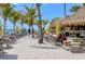 Outdoor seating with picnic tables under shade umbrellas on a sandy beach at 8855 Midnight Pass Rd, Sarasota, FL 34242
