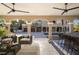 Spacious covered patio with outdoor kitchen and sitting area overlooking the driveway at 8855 Midnight Pass Rd, Sarasota, FL 34242