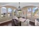 Dining room featuring arched windows, hardwood floors, and a modern chandelier at 8855 Midnight Pass Rd, Sarasota, FL 34242