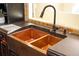 Copper farmhouse sink with black gooseneck faucet in kitchen at 8855 Midnight Pass Rd, Sarasota, FL 34242