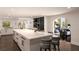 White modern kitchen with large island, bar seating, and stainless steel appliances at 8855 Midnight Pass Rd, Sarasota, FL 34242