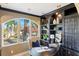 Home office with built-in shelving, arched window, and view of backyard at 8855 Midnight Pass Rd, Sarasota, FL 34242
