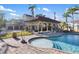 Backyard with a pool, a covered patio, lush landscaping, and palm trees at 8855 Midnight Pass Rd, Sarasota, FL 34242