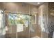Modern shower with multiple showerheads, mosaic tile accents, and a window view at 8855 Midnight Pass Rd, Sarasota, FL 34242
