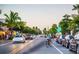 Personal biking down a street lined with parked cars and palm trees at 8855 Midnight Pass Rd, Sarasota, FL 34242