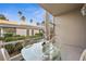 Screened patio with glass table and chairs, overlooking garden at 9611 Castle Point Dr # 912, Sarasota, FL 34238