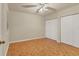 Bedroom with parquet wood floors, ceiling fan, and white closet doors at 1130 Villagio Cir # 203, Sarasota, FL 34237