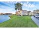 View of the apartment building exterior with lush landscaping and a pond at 1130 Villagio Cir # 203, Sarasota, FL 34237