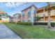 Front exterior view of a two-story condo building with lush landscaping and palm trees at 1130 Villagio Cir # 203, Sarasota, FL 34237