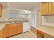 This kitchen boasts wood cabinets, white appliances, and a pass-through window at 1130 Villagio Cir # 203, Sarasota, FL 34237