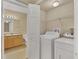 Laundry room with a stacked washer and dryer, wire shelving, and a view of the bathroom at 1130 Villagio Cir # 203, Sarasota, FL 34237
