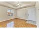 Spacious living room with parquet flooring, ceiling fan, and large window at 1130 Villagio Cir # 203, Sarasota, FL 34237