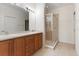 Bathroom featuring dual sinks, wooden cabinetry, a large mirror, and a walk-in shower at 11515 52Nd E Ct, Parrish, FL 34219