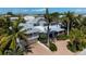 Aerial view of a two-story home with a metal roof, situated on a palm-tree lined street near the beach at 116 50Th St, Holmes Beach, FL 34217