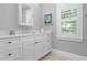 White bathroom vanity with modern fixtures, a large window with shutters, and tile flooring at 116 50Th St, Holmes Beach, FL 34217