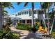 Two-story home with white siding, metal roof, and lush landscaping at 116 50Th St, Holmes Beach, FL 34217
