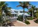 Beautiful multi-story home featuring lush tropical landscaping and a two-car garage at 116 50Th St, Holmes Beach, FL 34217