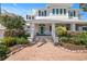 Two story home with white exterior, blue shutters, a light green door and brick walkway at 116 50Th St, Holmes Beach, FL 34217