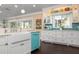 Charming kitchen with a farmhouse sink, teal appliances, and white cabinets at 116 50Th St, Holmes Beach, FL 34217