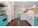 Bright, spacious kitchen with white shaker cabinets, turquoise appliances, and a farmhouse sink at 116 50Th St, Holmes Beach, FL 34217