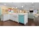 Open concept kitchen features a teal dishwasher and island with seating at 116 50Th St, Holmes Beach, FL 34217