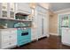 Kitchen features teal stove and white cabinets at 116 50Th St, Holmes Beach, FL 34217