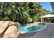 Inviting pool area with a waterfall feature, stone accents, and a covered patio at 116 50Th St, Holmes Beach, FL 34217