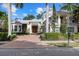 Two-story house with a metal roof, double door entry, and a brick driveway at 1805 Datura St, Sarasota, FL 34239