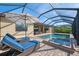 Relaxing patio space with a swimming pool, spa, lounge chairs, and outdoor grill at 20717 Benissimo Dr, Venice, FL 34293