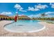 Large community pool with a beach entry and surrounding lounge chairs and umbrellas at 20717 Benissimo Dr, Venice, FL 34293